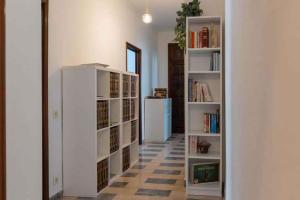 アラッシオにあるApartment in Alassio - Ligurische Riviera 48200の白い本棚と白い冷蔵庫が備わる廊下