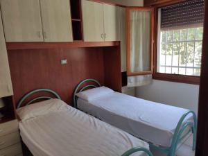 2 lits dans une chambre d'hôpital avec fenêtre dans l'établissement Holiday Homes in Rosolina Mare 48310, à Rosolina Mare