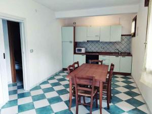 - une cuisine avec une table et des chaises en bois dans l'établissement Holiday Homes in Rosolina Mare 48310, à Rosolina Mare