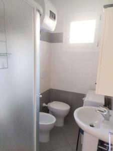 La salle de bains est pourvue de toilettes et d'un lavabo. dans l'établissement Holiday Homes in Rosolina Mare 48310, à Rosolina Mare