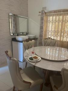 uma sala de jantar com uma mesa e cadeiras e um lavatório em PGD Homes & Lodges em Blantyre