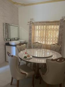una sala da pranzo con tavolo, sedie e lavandino di PGD Homes & Lodges a Blantyre