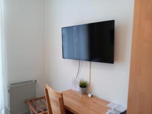 a flat screen tv hanging on a wall above a wooden table at Hotel Karolinger in Düsseldorf