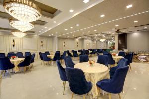 a banquet hall with tables and chairs and a chandelier at Southwest Inn - Boutique Hotel in New Delhi