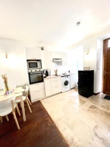 a kitchen with white appliances and a table and chairs at T2 situé au cœur du centre historique de Dinan in Dinan +3 photos