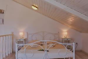 a bedroom with a white bed with two tables at Country House in Cunski