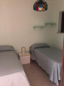 1 dormitorio con 2 camas y espejo en Residence l'Ogliastro, en Petrizzi