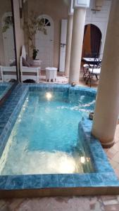 una piscina con azulejos azules en una casa en RIAD AWINATI Location Privatisée ,piscine chauffée, en Marrakech