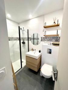 uma casa de banho com um WC, um lavatório e um chuveiro em T2 situé au cœur du centre historique de Dinan em Dinan