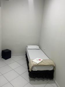 ein kleines Schlafzimmer mit einem Bett in einem weißen Zimmer in der Unterkunft Hostel São João in Araçariguama