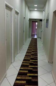 - un couloir avec un long tapis au sol dans l'établissement Hostel São João, à Araçariguama