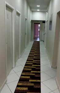 a hallway with a long rug on the floor at Hostel São João in Araçariguama +1 photo