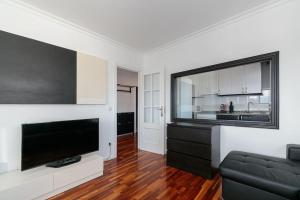 Moderno piso en el corazón de Baiona by CABANA Rentals في بايونا: غرفة معيشة مع تلفزيون بشاشة مسطحة وأريكة