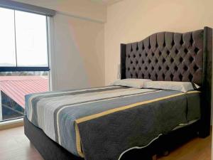1 dormitorio con 1 cama grande y ventana grande en Moderno departamento Vallecito, en Arequipa