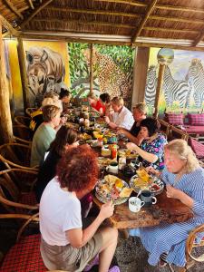 a group of people sitting at a table eating food at Safari villa in Arusha