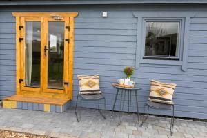 een blauw huis met een houten deur en twee stoelen bij The Apiary in Killarney