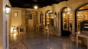 a room with tables and chairs in a library at The Literary Man Obidos Hotel in Óbidos