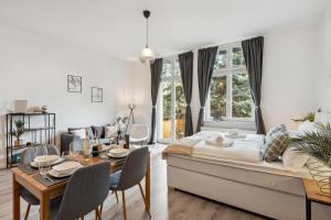1 dormitorio con 1 cama, mesa y sillas en Homespace - Magdeburg - Gemütliches Apartment mit Balkon en Magdeburgo