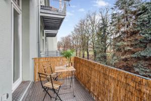 un patio con 2 sillas y una mesa en el balcón en Homespace - Magdeburg - Gemütliches Apartment mit Balkon en Magdeburgo