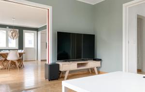 sala de estar con TV de pantalla plana grande en la pared en Nice Home In Lyngdal With House A Panoramic View en Lyngdal