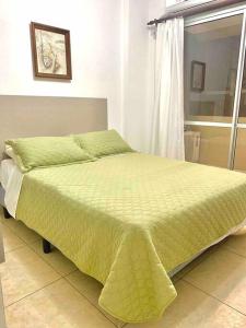 a bedroom with a bed with a yellow blanket on it at Hermoso y cómodo departamento en Salta in Salta
