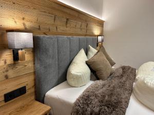 Schlafzimmer mit einem Bett mit grauem Kopfteil in der Unterkunft Natur & Familienhotel Der Stieglerhof in Radstadt