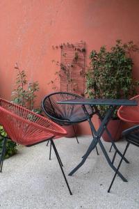 uma mesa e duas cadeiras em frente a uma parede vermelha em E Fauvette appartement de standing avec terrasse em Épernay