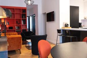 een woonkamer met een tafel en stoelen bij E Fauvette appartement de standing avec terrasse in Épernay