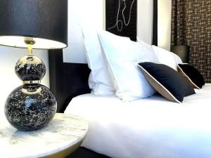 uma cama com uma mesa com um candeeiro em E Fauvette appartement de standing avec terrasse em Épernay