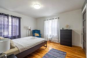 een slaapkamer met een bed, een dressoir en een blauwe stoel bij Large & Sunny Beautiful Home #103 in Halifax