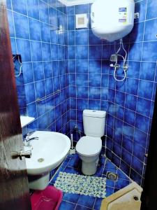 a blue tiled bathroom with a toilet and a sink at Porto Matroh ViP Spechial in Marsa Matruh