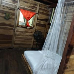 a bedroom with a bed and a window with a curtain at the mompe beach hostal in La Poza