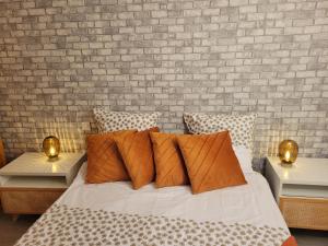 ベルサイユにあるLe duplex du cocon de versaillesのレンガの壁とベッド(枕付)が備わるベッドルーム1室が備わります。