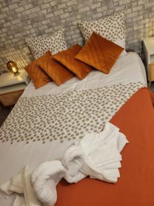 ベルサイユにあるLe duplex du cocon de versaillesのベッド(オレンジ&白のシーツ、枕付)