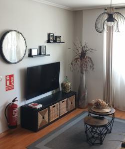 sala de estar con TV de pantalla plana y mesa en Apartamento "Los Prados" wifi y parking en Oviedo