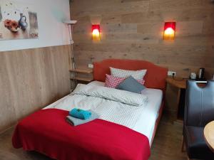a bedroom with a bed with a red blanket at Landhotel Waldschlößchen in Sohland