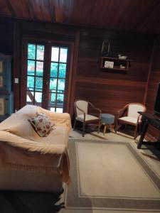 um quarto com uma cama e cadeiras e um piano em Paz na Serra Teresopolis em Teresópolis