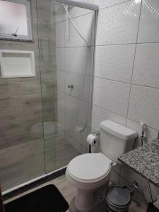 a bathroom with a toilet and a glass shower at Paz na Serra Teresopolis in Teresópolis