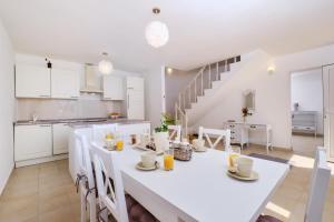 a kitchen and dining room with a white table and chairs at Country House in Cunski