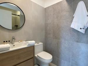 een badkamer met een toilet, een wastafel en een spiegel bij La Mar Miraflores by Wynwood House in Lima