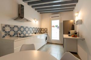 cocina con armarios blancos, mesa y ventana en Victoria Seis, en Medina Sidonia