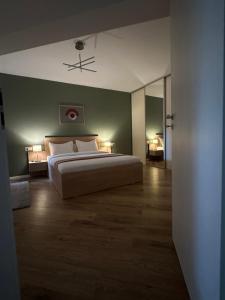 una camera con un letto bianco e una parete verde di MM Residence a Cluj-Napoca