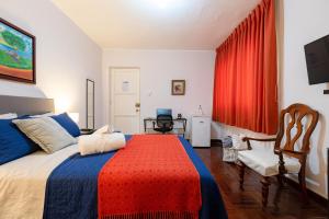 Charming Miraflores Guesthouse with Terrace Studio Apartment and Private Room في ليما: غرفة نوم بسرير كبير وستارة حمراء