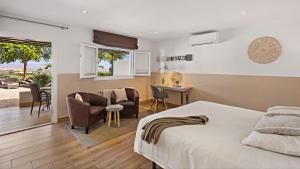 a bedroom with a bed and a desk and chairs at Boutique Hideaway Cortijo El Sarmiento - Adults Only in Mojácar +62 photos
