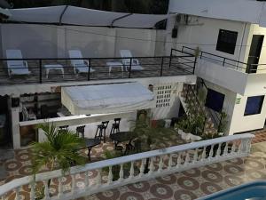 uma varanda de uma casa com uma cama e cadeiras em Hotel CAB DE TOLU em Tolú