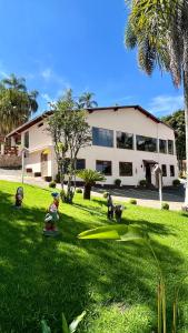 a house with some toy figurines in the grass at Hotel Varandas do Sol in Poços de Caldas