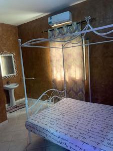 1 dormitorio con cama de metal y TV en la pared en Résidence Les Bernier en Nianing
