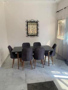 Nianing的住宿－Résidence Les Bernier，餐桌、椅子和墙上的照片