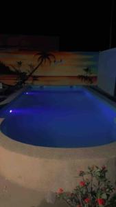 una gran piscina azul en una habitación en Résidence Les Bernier en Nianing