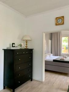 sypialnia z łóżkiem i komodą z zegarem w obiekcie Smakfull centrumlägenhet, 3 r + k, 80 m2 w mieście Maarianhamina